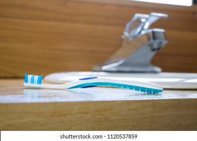 
Blue Toothbrush On Bathroom Counter In Front Of Sink