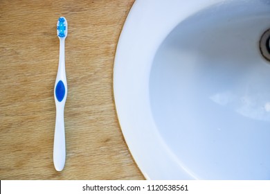 Blue Toothbrush On Bathroom Counter Next To Sink