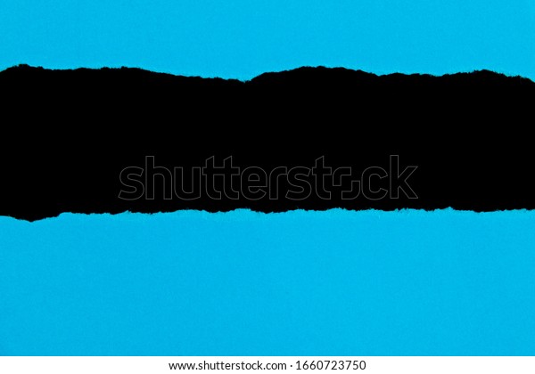 Blue torn paper on black\
background.