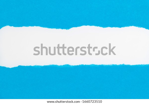 Blue torn paper on white\
background.