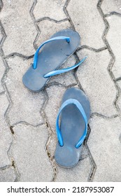 Blue Torn Shoes Placed On The Gray Block Corridor