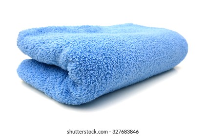 A Blue Towel Rolled Up On A White Background