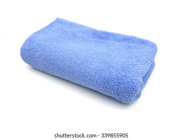 A Blue Towel Rolled Up On A White Background