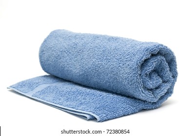 A Blue Towel Rolled Up On A White Background