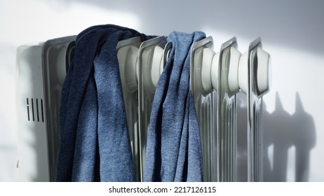 blue towel sweater clothes hanging to dry on oily new radiator, home radiator on white background, clothes on dryer - Powered by Shutterstock