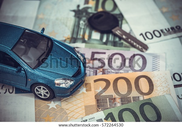 blue toy car and euro money coin and banknotes.\
toned image