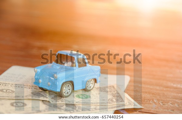 Blue toy car on dollar money with column graph ,\
Money saving for car\
concept