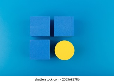 Blue toy cubes and yellow circle on dark blue background. Concept of individuality, being different from others, leadership or unique ideas 