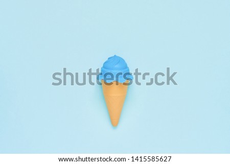 Blue toy ice-cream on lighn blue background. Minimalism, summer concept. Top view, copy space.