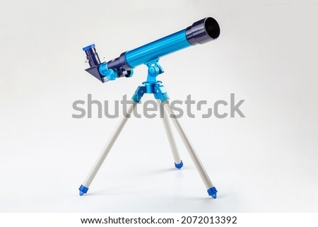 Blue toy telescope on a tripod, single object isolated on white background. Stargazing, space observation science instruments, tools for young kids, children, astronomy hobby conceptual symbol, nobody