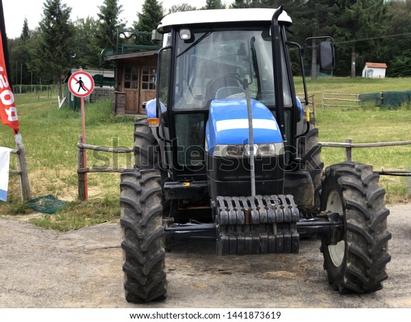Blue\
tractor near the field. Agricultural industry\
