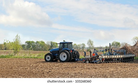 Blue Tractor Pulling A Planter Planting Corn