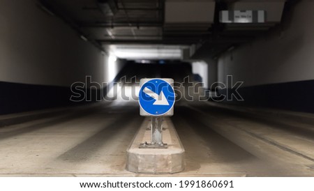 Blue traffic sign with directional arrow and two lanes