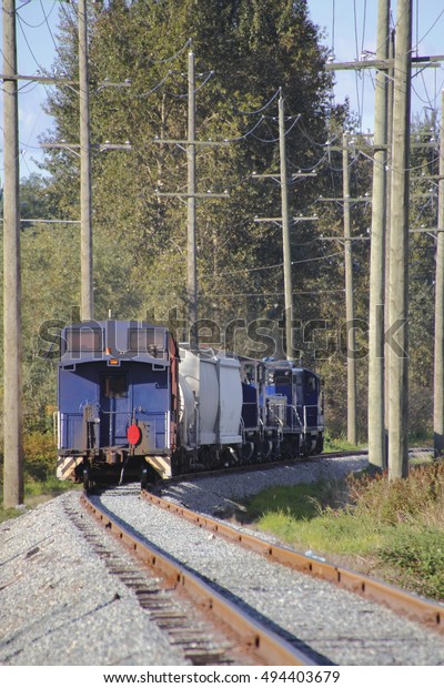 A blue train car or caboose winding down the track/Train\
Car Caboose/A blue train car or caboose winding down the track.\
