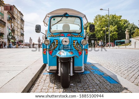 Blue tricycle tuk tuk waiting for tourist on the street of Porto, Portugal