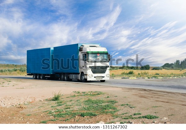 Blue truck\
with a white cab moves on the\
highway