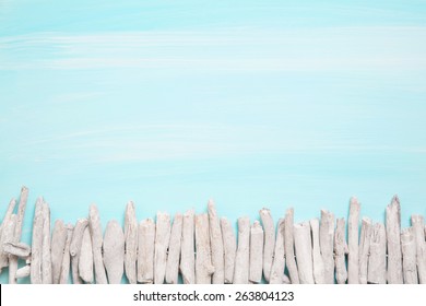 Blue or turquoise oceanic background with a fence of driftwood for maritime decorations.