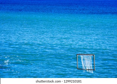 Blue And Turquoise Sea, A Water Polo Net On The Right Side