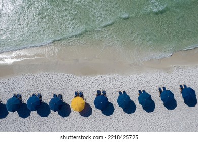 Blue Umbrellas On Beach Gulf Coast Panhandle Florida White Sandy Beach Clear Emerald Waters Fly Over With A Drone Aerial View Bright Sunny Day 