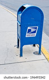 A Blue US Post Office Box On Sidewalk Corner.