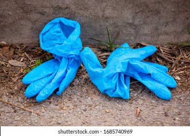 Blue Used Latex Surgical Gloves On The Ground.