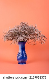 Blue Vase With Dried Flowers On An Orange Background. Minimalist Decor
