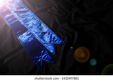 Blue Velvet Winner Sash For Miss Pageant Beauty Contest, Empty Area For Text Winner Country Word, Studio Lighting Abstract Dark Drapping Textile Background, Importance Decoration Shoulder To Waist