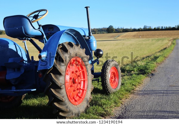 Blue vintage tractor in\
close-up field