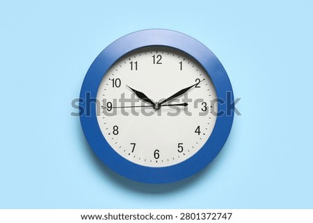 Blue wall clock showing time at 10:10