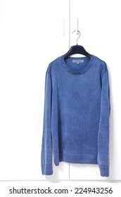 Blue Warm Long Sleeve Shirt On Black Hanger Hang On White Closet Door