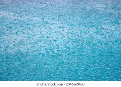 Blue Water Background With Rain Drops. Downpour Drops On Water Surface. Ripple On Pool Surface. Blue Shiny Agua Backround. Rain Splash On Water. Liquid Textured. Water Wallpaper.