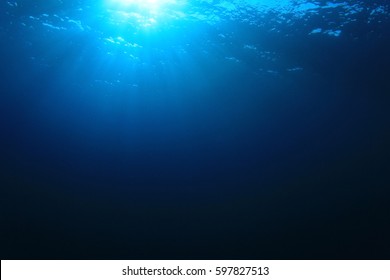 Blue water background and sunlight underwater - Shutterstock ID 597827513