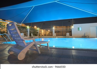 Blue Water In A Clean Swimming Pool At Night. The Pool Is Covered With A Blue Shade Net Roof ? HDR Type Image