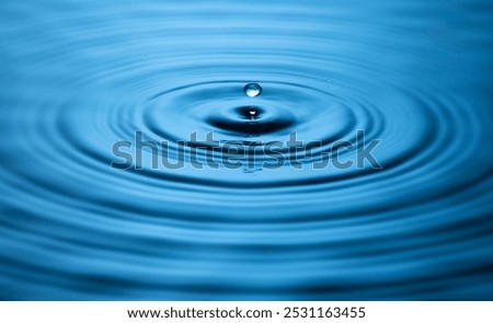 Blue Water drop falling, macro splash. Natural background.