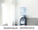 Blue water gallon on water cooler in office.