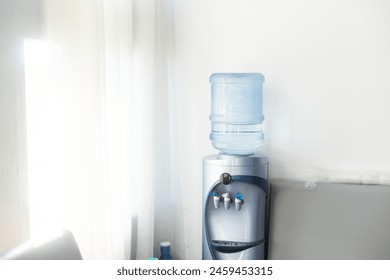 Blue water gallon on water cooler in office. - Powered by Shutterstock