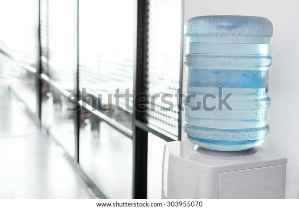 blue\
water gallon on electric water cooler in office\
area