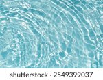 Blue water with ripples on the surface. Defocus blurred transparent blue colored clear calm water surface texture with splashes and bubbles. Water waves with shining pattern texture background.