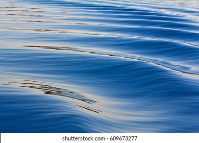 Blue water with slight waves on the surface with reflection