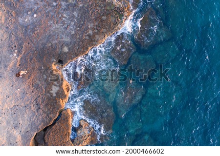 Aerial Drone View Of Dramatic Ocean Waves Crushing On Rocky Landscape