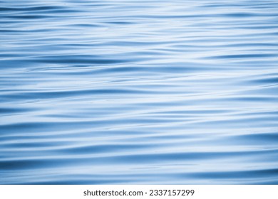 Blue water surface with a pattern of soft waves, background photo texture