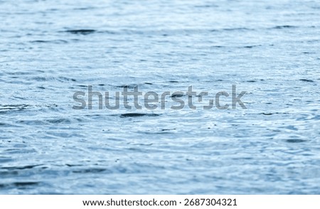 Blue water surface with ripple pattern, natural photo background with selective focus