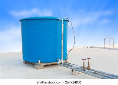 Blue water tank of industrial building on roof top or deck and blue cloud sky background