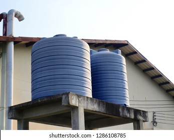 Blue water tank on the tower: plastic water tank installed on the back of the factory For storing water used in food production or reserving water for emergency use.