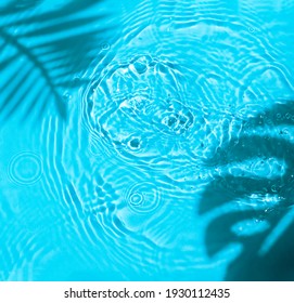 Blue water texture background on the noon sunlight with  tropical leaves shadow. 
