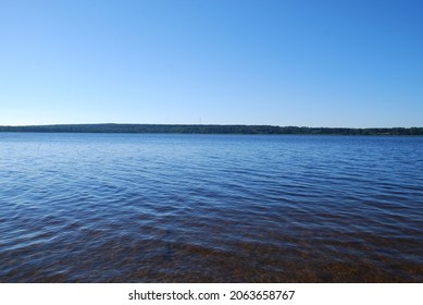 Blue water in the Vuoksa river. A summer day, a wide flood of the river with blue water, a green forest grows on the other side of the river, occupying all the space on the bank. - Shutterstock ID 2063658767