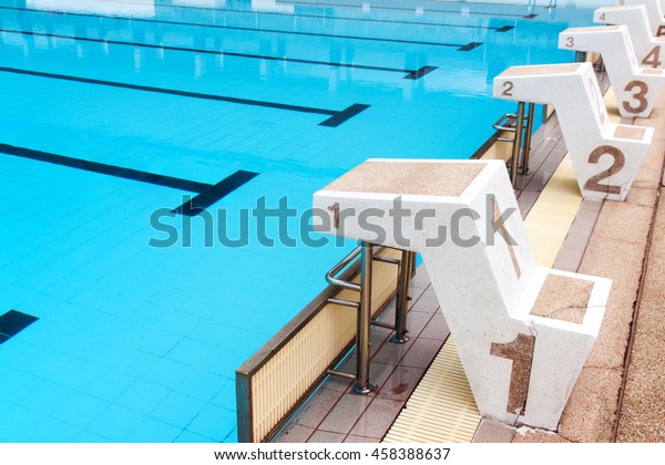 blue water\
wave in swimming pool reflects with sunlight , blue tile ceramic to\
swimming race and water\
sports.