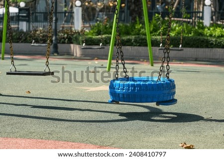 Blue wheel tire rubber swing on the playground in the courtyard of an apartment house.