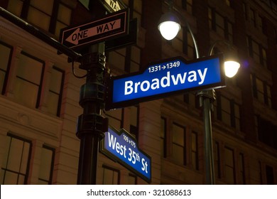 A Blue And White Backlit Sign At Night For Broadway In New York City