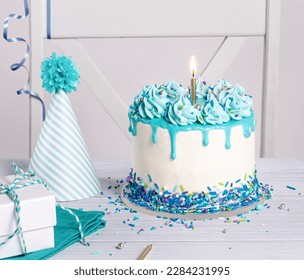 Blue and white Birthday party with cake, gifts and hat over white background.